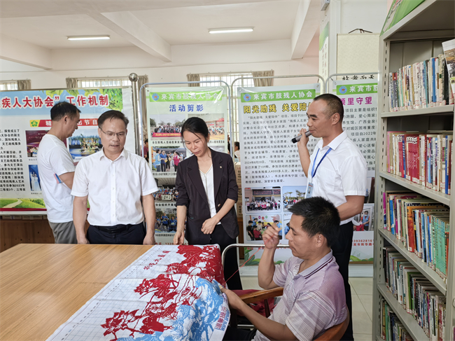 图为与会人员参观来宾市肢残人协会